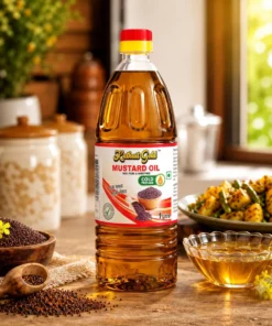 Kathait Gold 1 litre cold pressed mustard oil bottle on a wooden kitchen table with cooked sabzi, mustard seeds, and oil in a glass bowl.