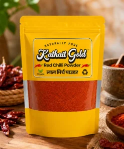 Kathait Gold Red Chilli Powder pouch placed on a wooden table with whole red chillies and ground spice bowl